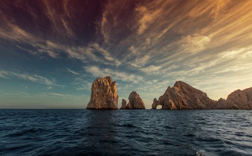 A beautiful view of the Arch of Cabo San Lucas under the cloudy sunny sky
