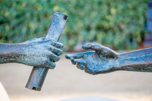 Sculpture of two hands delivering a parchment, agreement of two persons. Political consensus