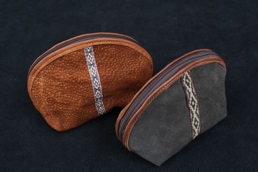 A closeup shot of the two antique leather cosmetic bags isolated on the black background