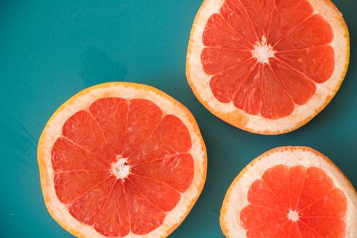 A closeup of a sliced grapefruit on the blue background, cut grapefruit