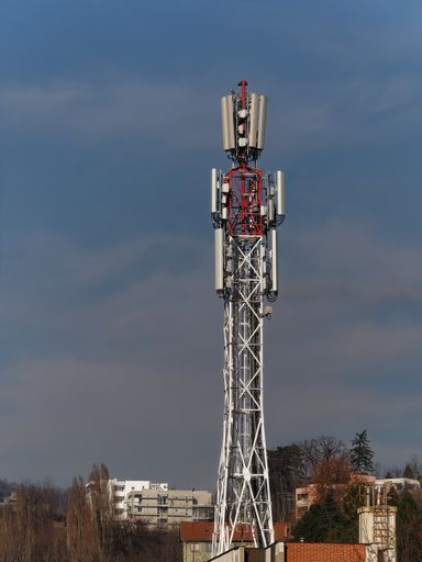 Communication tower on top of the roof of the building under the blue sky