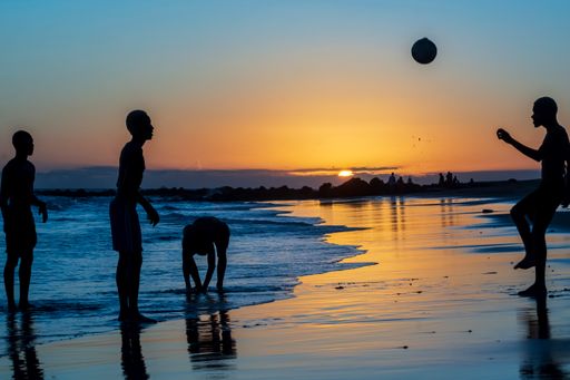 Young people playing sand football at sunset on Ondina beach in Salvador, Bahia, Brazil.