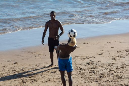 The young people playing sand football on the beach of Ondina in the afternoon sun, Salvador, Bahia, Brazil