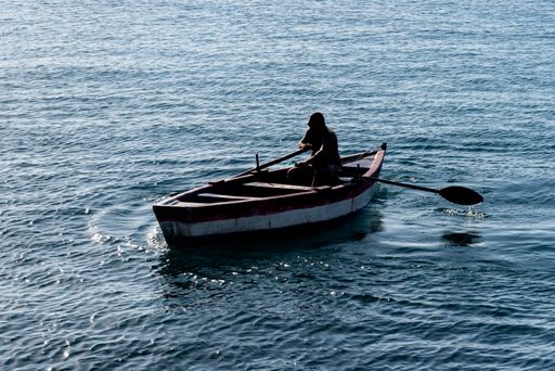 A person rowing a boat at sea. Salvador, Bahia, Brazil