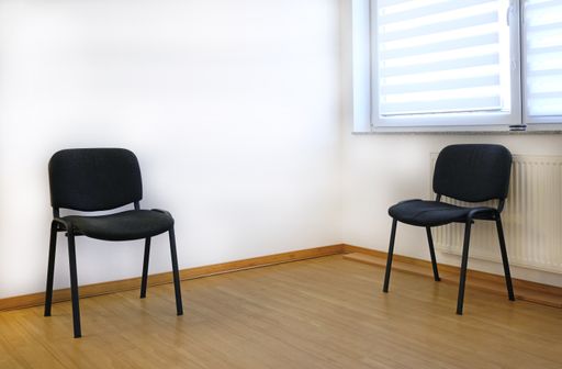 A simple office room interior with chairs near the window
