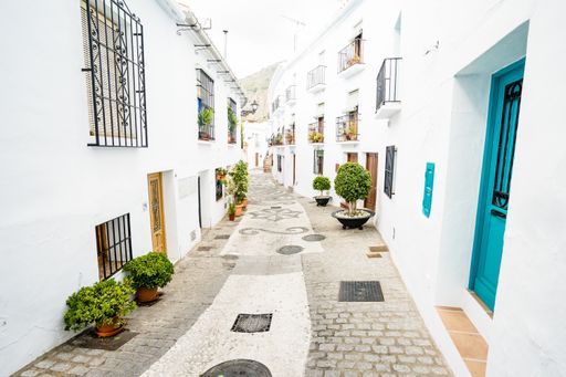A narrow street between typical white buildings in Frigiliana, Andalusia, Spain