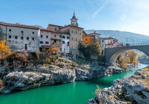 Idyllic old town on rocky bank of green river on a sunny day in autumn. Kanal ob Soci is a gorgeous tourist and travel destination in Slovenia