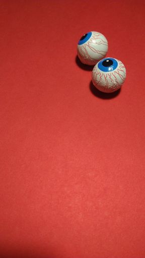The candy chocolate eyes of Halloween isolated on a red background