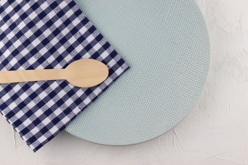 The wooden disposable spoons with a blue plate and a checkered napkin