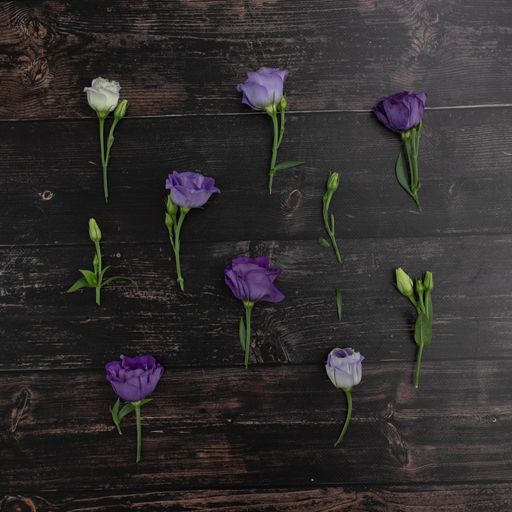 A high angle shot of purple lisianthus flowers on a wooden surface