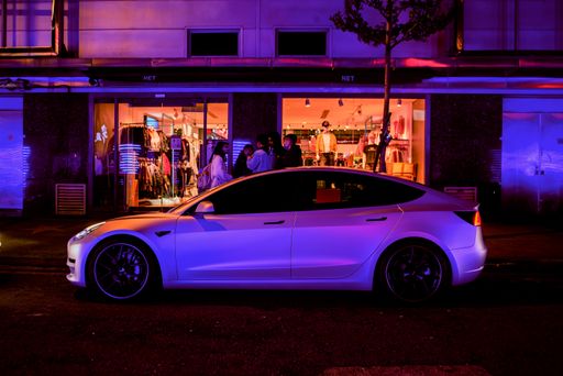 A Tesla car parked outdoors in front of a nightclub at night in Xinyi District of Taipei, Taiwan