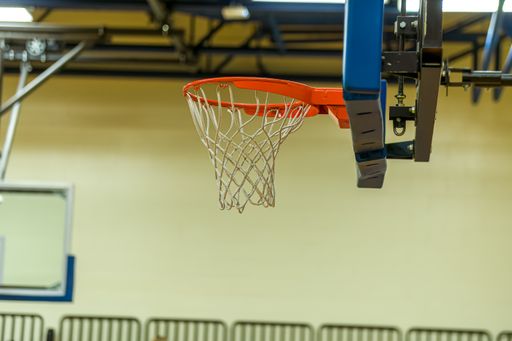 A closeup of a basketball ring with a net hanging on a backboard