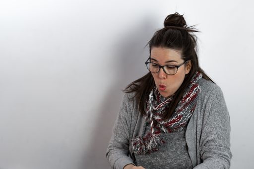 young brunette girl with long hair and glasses with a surprised expression while reading a book