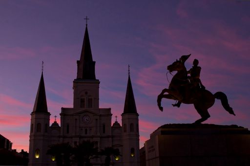 Saint Louis Cathedral and statue of General Andrew Jackson in silhouette at sunset in the New Orleans French Quarter