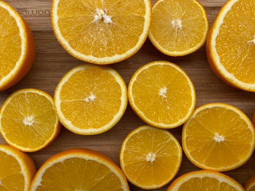 A vertical shot of freshly sliced seedless oranges on a wooden surface