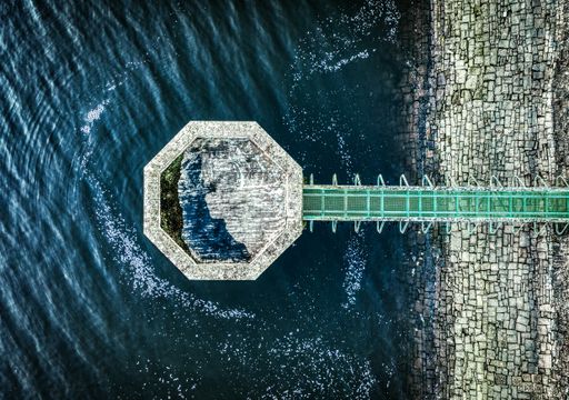 A high angle shot of a beautiful wooden pier on the surface of the ocean