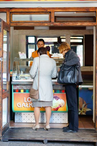 A closeup of two women buying ice cream by a stand