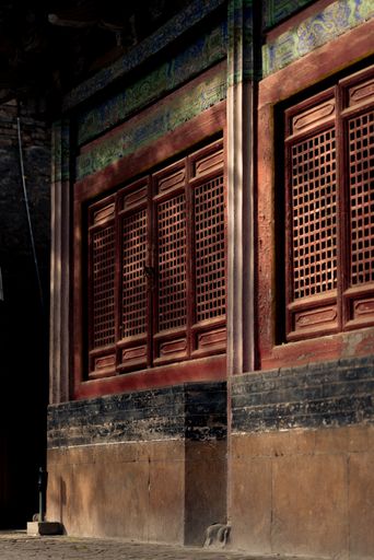 A vertical shot of an old building with weathered windows