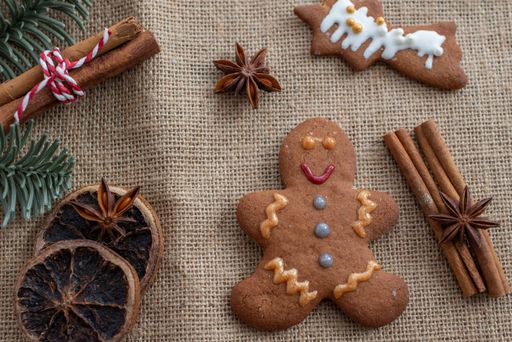 A top view of a delicious gingerbread cookie with cinnamon sticks and dried fruits next to it