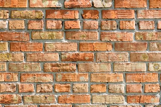 A closeup of old brick walls have an orange color and a weathered texture