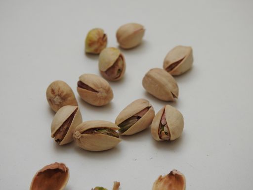 A closeup shot of pistachio seeds with shell isolated on white background