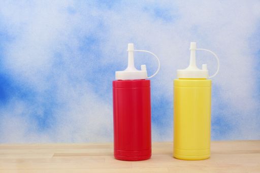 The bottles of ketchup and mustard isolated on blue textured background