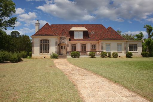 A closeup of an abandoned Historic Brick House With Blue Sky and Clouds