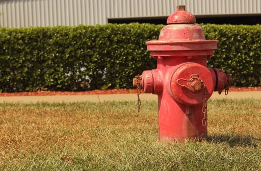 A closeup of a vintage Red Fire Hydrant in Front of City Building