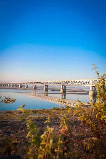 A vertical shot of a suspension bridge over the Brahmaputra river in Tibet under a blue sky