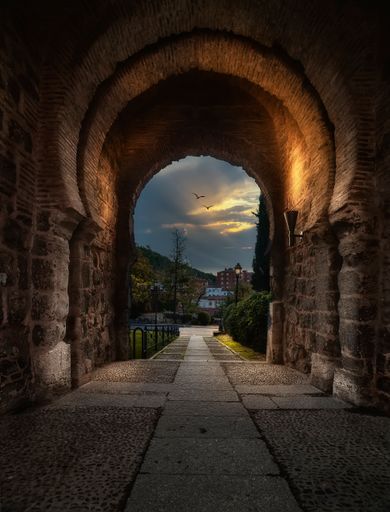 A vertical shot of sky trough an old building's arch