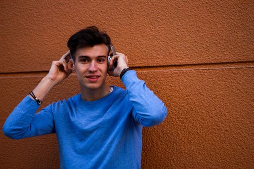 A young attractive male posing while putting on headphones