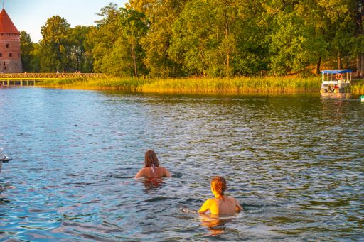 A beautiful view of two young girls are swimming in the ancient Lithuanian castle of Trakai