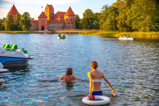 A beautiful view of two young girls are swimming in the ancient Lithuanian castle of Trakai