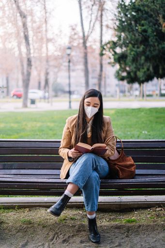 A closeup of a girl sitting on a bench in a park