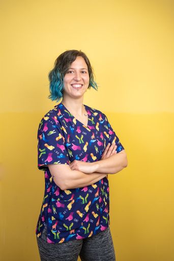 A portrait of a happy caucasian physiotherapist in the clinic against the background of a yellow wall