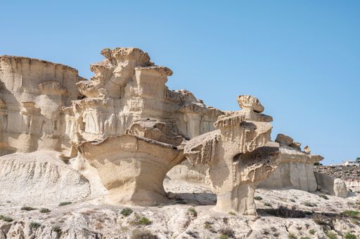 A scenic view of Las Gredas de Bolnuevo mountains in Spain under a blue sky on a sunny day