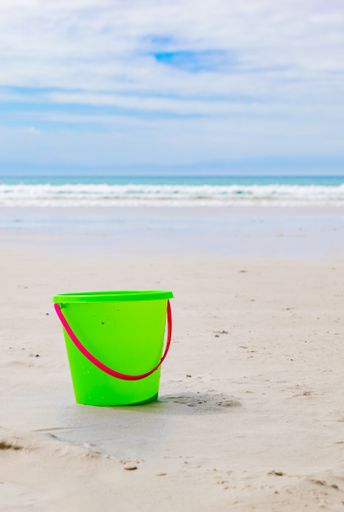A closeup of Colourful Plastic Kids Bucket for making sandcastles on a sandy beach
