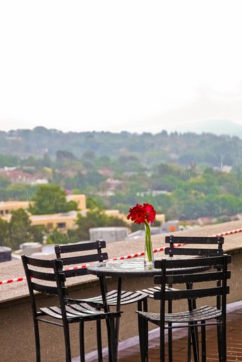 A vertical shot of a flower in a small vase on an outdoor table