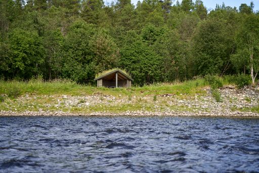 A beautiful view of Fisher sheds by the Alta river in Norway with trees on the other side