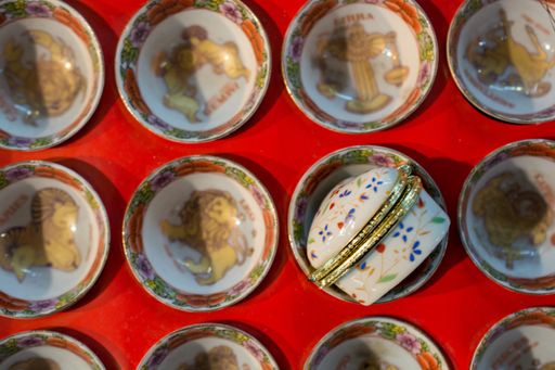 A top view of antique ceramic bowl and container collection on a red surface