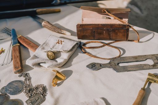 A closeup of coins, cards, and old items on a wooden table