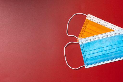 Top view of a table with colorful face masks piled and space to copy