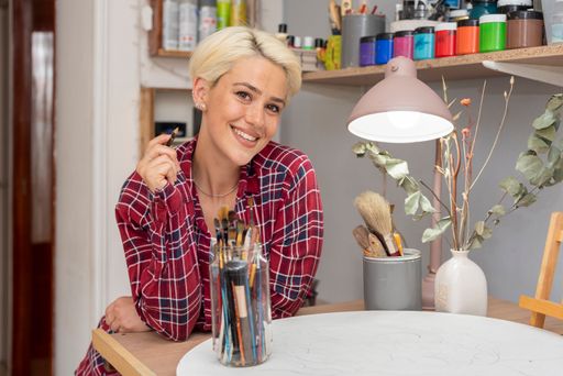 A beautiful Hispanic blonde female artist working in her studio