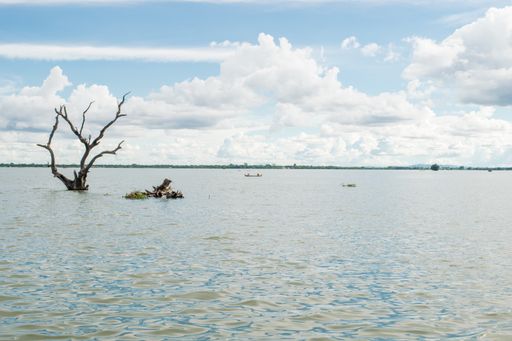 View of Taungthaman Lake near Amarapura, close to Mandalay in Myanmar, Burma, as seen from U-Bein Bridge, before sunset on a cloudy day during monsoon