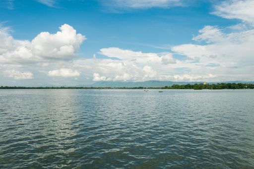 View of Taungthaman Lake near Amarapura, close to Mandalay in Myanmar, Burma, as seen from U-Bein Bridge, before sunset on a cloudy day during monsoon