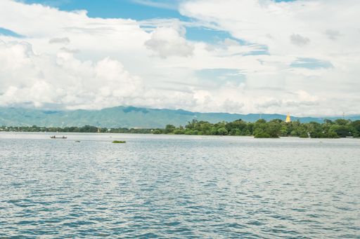 View of Taungthaman Lake near Amarapura, close to Mandalay in Myanmar, Burma, as seen from U-Bein Bridge, before sunset on a cloudy day during monsoon