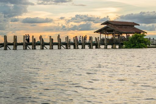View of U-Bein bridge, built of teak wood, during sunset, in Taungthaman Lake near Amarapura, close to the city of Mandalay in Myanmar, Burma, SE Asia