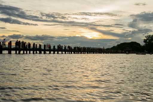 View of U-Bein bridge, built of teak wood, during sunset, in Taungthaman Lake near Amarapura, close to the city of Mandalay in Myanmar, Burma, SE Asia
