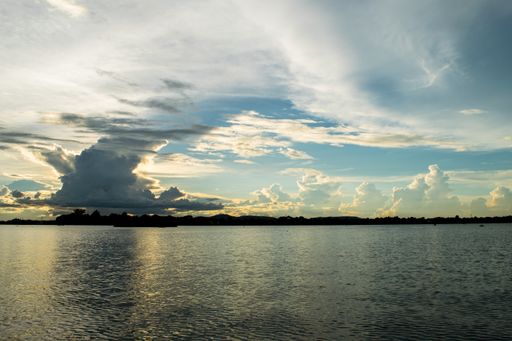 View of Taungthaman Lake near Amarapura, close to Mandalay in Myanmar, Burma, as seen from U-Bein Bridge, before sunset on a cloudy day during monsoon