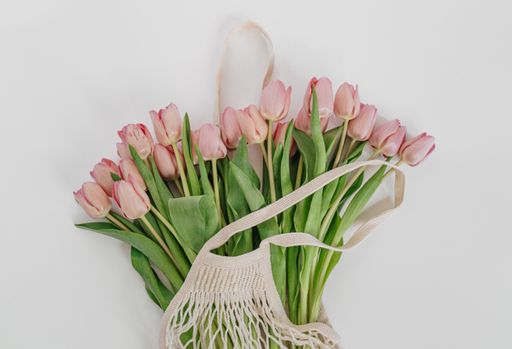 A closeup shot of the bouquet of pink tulips in an eco net string bag